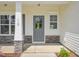 Charming front entrance with stone accents, number 18, grey door, and decorative shrubbery at 18 Hewitt Woods Dr, Clayton, NC 27527