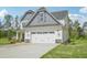 Two-story home with a spacious two-car garage, gray accents, and a well-manicured lawn and stone accents at 18 Hewitt Woods Dr, Clayton, NC 27527
