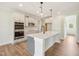 Bright kitchen with a large island, quartz countertop, stainless steel appliances, and modern pendant lighting at 18 Hewitt Woods Dr, Clayton, NC 27527