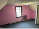 Pink-walled bedroom features sloped ceilings and a window at 2324 Lonnie Cir, Hillsborough, NC 27278