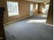 Spacious living room enhanced by neutral carpeting, bright windows, and paneled walls at 2324 Lonnie Cir, Hillsborough, NC 27278