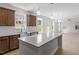 Kitchen with stainless steel sink, white backsplash, island, and wood cabinets at 257 North Maple Walk Dr # 218, Garner, NC 27529