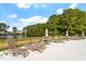 Community pool area with several lounge chairs and umbrellas overlooking a lake surrounded by woods at 257 North Maple Walk Dr # 218, Garner, NC 27529