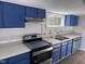 Modern kitchen with blue cabinets and stainless steel appliances at 3612 Mt Zion Church Rd, Mebane, NC 27302