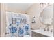 Updated bathroom with a modern vanity and a decorative shower curtain at 402 W Clay St, Mebane, NC 27302