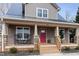 Two-story house with gray siding, red door, and rocking chairs on the porch at 402 W Clay St, Mebane, NC 27302