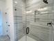 Shower with a glass door, tiled walls, recessed shelves, and modern fixtures at 4321 Darius Ln # 23, Fuquay Varina, NC 27526