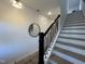 Stylish staircase with a black handrail, complemented by a round mirror on the adjacent wall at 4321 Darius Ln # 23, Fuquay Varina, NC 27526