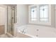 Bathroom with soaking tub, glass shower, and stained glass windows at 5072 Aspen Meadow St, Raleigh, NC 27616