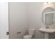 Clean bathroom with pedestal sink, toilet, and oval mirror at 572 Glenkirk Pl, Garner, NC 27529
