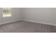 Bright bedroom with grey carpet and a window at 572 Glenkirk Pl, Garner, NC 27529