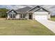 Two-story house with a beige exterior, gray roof, and white garage door at 572 Glenkirk Pl, Garner, NC 27529