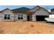 New construction home featuring large windows and attached two-car garage awaiting its finishing touches and landscaping at 572 Glenkirk Pl, Garner, NC 27529