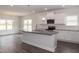 Spacious kitchen featuring granite island, white cabinets, and hardwood floors at 572 Glenkirk Pl, Garner, NC 27529