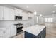 Bright kitchen with white cabinets, stainless appliances, island, and view into the living room at 704 Georgia'S Landing Pkwy # 15, Raleigh, NC 27603