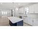 Open-concept kitchen featuring white cabinets, an island, and views into the living area at 704 Georgia'S Landing Pkwy # 15, Raleigh, NC 27603