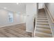 View of staircase and hardwood floors leading to an open living area filled with natural light at 704 Georgia'S Landing Pkwy # 15, Raleigh, NC 27603