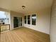 Comfortable outdoor back porch with wooden floors, bright light, and sliding glass door at 93 Ausban Ridge Ln # 033, Four Oaks, NC 27524