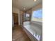 Bright bathroom showcasing a soaking tub, glass shower, and modern fixtures at 93 Ausban Ridge Ln # 033, Four Oaks, NC 27524