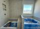Modern bathroom featuring tile surround, soaking tub and bench in the tiled shower with natural light at 93 Ausban Ridge Ln # 033, Four Oaks, NC 27524