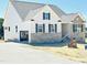 Charming two-story home boasts brick accents, an attached garage, and newly paved driveway at 93 Ausban Ridge Ln # 033, Four Oaks, NC 27524