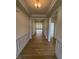 Inviting hallway featuring wood-look flooring, elegant trim, and an open layout leading to the living spaces at 93 Ausban Ridge Ln # 033, Four Oaks, NC 27524