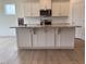 Stylish kitchen island featuring granite countertops, white cabinets and stainless steel appliances at 93 Ausban Ridge Ln # 033, Four Oaks, NC 27524