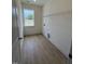 Bright laundry room with wood floors, window view, and wire shelving for organized storage at 93 Ausban Ridge Ln # 033, Four Oaks, NC 27524