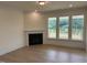 Living area showcasing a cozy fireplace and three bright windows overlooking the front yard at 93 Ausban Ridge Ln # 033, Four Oaks, NC 27524