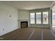 Bright living room with a fireplace, large windows overlooking the exterior of the home, and elegant crown molding at 93 Ausban Ridge Ln # 033, Four Oaks, NC 27524