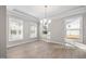 Bright dining room with wood floors, elegant chandelier, and large windows at 102 Belmont Stakes Ln, Wendell, NC 27591