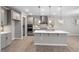 Modern kitchen with stainless steel appliances, an island, pendant lights, and wood-look flooring at 102 Belmont Stakes Ln, Wendell, NC 27591