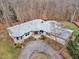 An elevated view highlights the property, showcasing stone accents, lush landscaping, and mature trees at 1126 Trailwood Dr, Raleigh, NC 27606