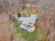 Aerial view of a house featuring an expansive deck, a well-kept lawn, and mature trees at 1126 Trailwood Dr, Raleigh, NC 27606