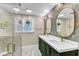 Beautiful bathroom featuring a double vanity, wallpaper, and a glass shower door at 1126 Trailwood Dr, Raleigh, NC 27606