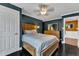 Comfortable bedroom featuring a wooden bed frame, dark walls, and a ceiling fan at 1126 Trailwood Dr, Raleigh, NC 27606