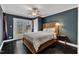 Cozy bedroom with French doors, dark walls, hardwood floors, and a ceiling fan at 1126 Trailwood Dr, Raleigh, NC 27606