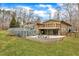 Back exterior showcasing the deck, lower patio, and outdoor seating, with a well-manicured lawn at 1126 Trailwood Dr, Raleigh, NC 27606