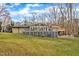 Rear view featuring a deck and patio with outdoor seating, overlooking the lush backyard and mature trees at 1126 Trailwood Dr, Raleigh, NC 27606