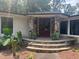 Elegant entryway with double doors, stone columns, and lush landscaping at 1126 Trailwood Dr, Raleigh, NC 27606