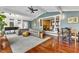 Spacious living room featuring hardwood floors, a gray sofa, and a view to the kitchen at 1126 Trailwood Dr, Raleigh, NC 27606