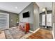 Living room boasts hardwood floors, neutral walls, a mounted television, and access to the backyard at 1126 Trailwood Dr, Raleigh, NC 27606
