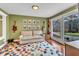Sitting Room with large window, sofa, guitars on wall and colorful rug at 1126 Trailwood Dr, Raleigh, NC 27606