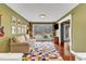 Sitting Room with sofa, guitar, and large windows view of wooded yard at 1126 Trailwood Dr, Raleigh, NC 27606