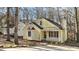 Nice yellow house with a white porch, and mature trees in the background at 1322 Cedar Branch Ct, Wake Forest, NC 27587