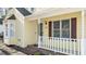 Front porch with white railing, brick steps, and brown shutters at 1322 Cedar Branch Ct, Wake Forest, NC 27587