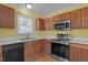 Modern kitchen with stainless steel appliances and wood cabinets at 1322 Cedar Branch Ct, Wake Forest, NC 27587
