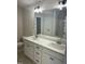 Bathroom with double sink vanity, large mirror, vanity lighting, white cabinets, and a shower at 233 N Movado Trl, Kenly, NC 27542