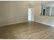 Spacious living room with light-colored walls, hardwood floor, and an open view into the kitchen at 233 N Movado Trl, Kenly, NC 27542