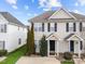 Tan two-story house with black shutters and a tree in the front at 2332 Turtle Point Dr, Raleigh, NC 27604